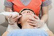 © PAVEL GERASIMENKO - A beautiful girl takes the procedure of ultrasonic facial cleaning in a beauty salon.