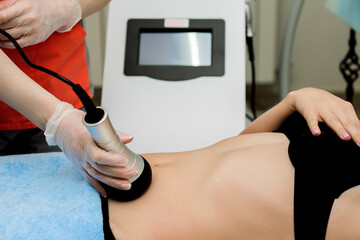 Wall Mural - A woman in a beauty salon receives a vacuum abdominal massage, Hardware cosmetology.