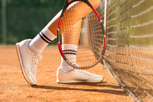 Female Tennis Player Legs And Her Racket Near The Net