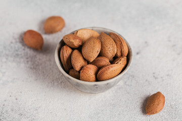 Pile of Almond nuts in a bowl on a white background