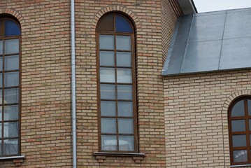 Poster - one big window on a brown brick wall of a building 