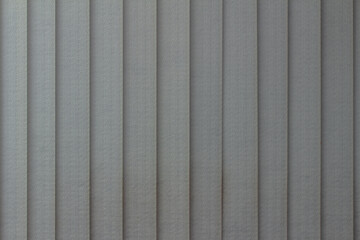 Full frame abstract art design texture background of vertical window blinds in a gradient shade of gray