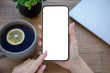 © DenPhoto - female hands holding golden phone with isolated screen in office