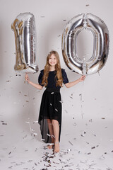 Wall Mural - Little ten years old girl posing with air balloons and confetti over white