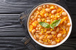 Delicious slow-stewed beans with corn, pumpkin and onions close-up in a bowl on the table. horizontal top view from above