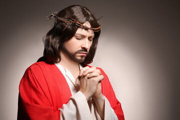 Poster - Jesus Christ with crown of thorns praying on beige background, space for text