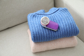 Sticker - Modern fabric shaver and woolen sweaters on sofa indoors