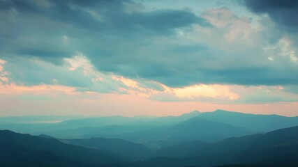 sunset and clouds over the silhouettes of the mountains. fast motion