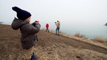 4 Years Old Boy Is Taking Photo Or Video Of Marine Landscape. Father Is Filming His Daughter On The Background