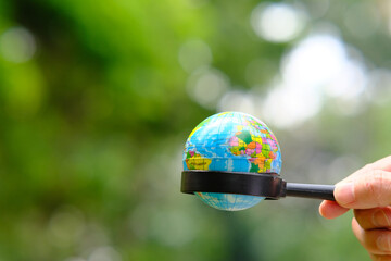 Poster - Businessman hand holding earth on green background and and business growth concept, global investment concept