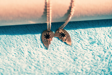 Wall Mural - Set of best friends best buds heart necklace shoot outside in a summer day closeup. Selective Focus. High quality photo