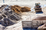 Fototapeta Łazienka - backhoe loader near construction mixes on the ground, construction material