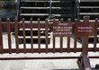Opening hour signage on a barrier surrounding a temple in Angkor Wat Complex