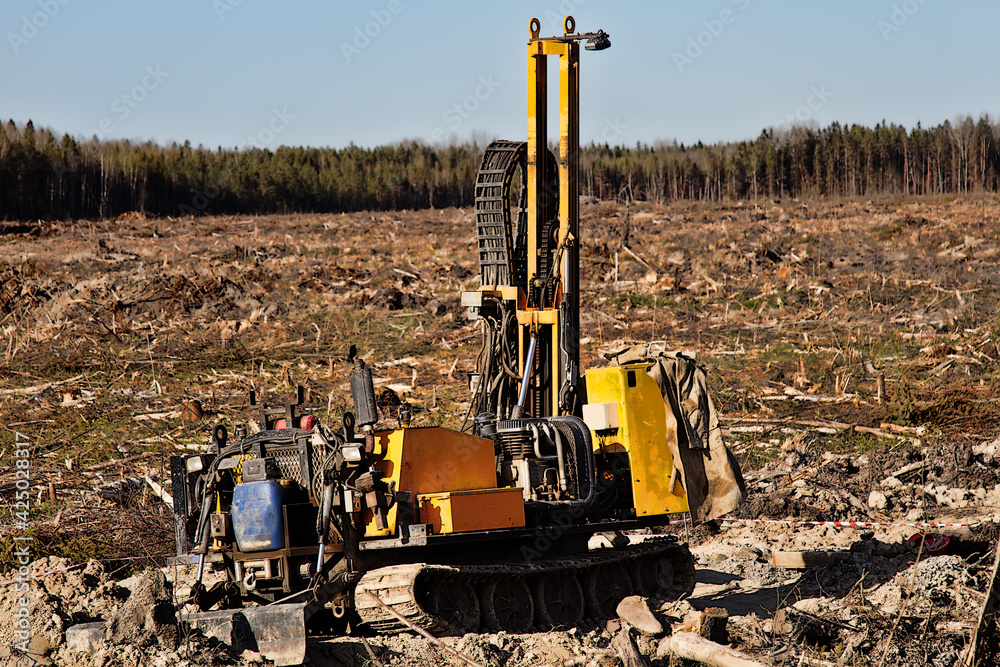 Forest Rig Mini-drilling rig on crawler track on site of sawn forest where large ...