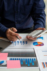 Wall Mural - businessman working on desk office with using a calculator to calculate the numbers, finance accounting concept