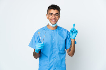 Brazilian dentist holding tool isolated on white background showing and lifting a finger in sign of the best