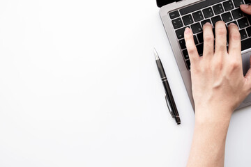 Man hands are typing on laptop computer keyboard over white office desk table. Top view with copy space, flat lay.