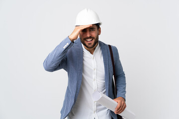 Wall Mural - Young architect man with helmet and holding blueprints isolated on white background looking far away with hand to look something