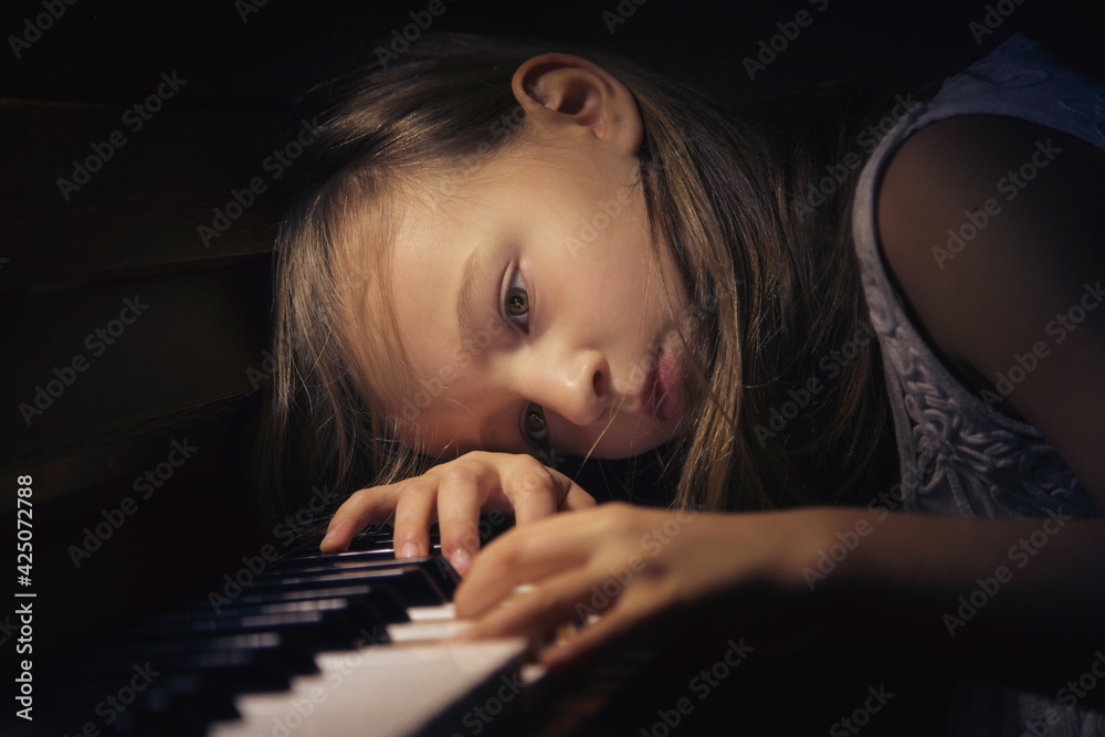 Dziewczyna w zadumie grająca na pianinie. - obrazy, fototapety, plakaty 