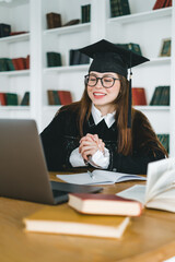 Happy young caucasian woman celebrating college graduation during a video call with friend or family. Online graduation ceremony concept