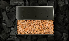 Metal Smoker Box With Wood Chips On Charcoal