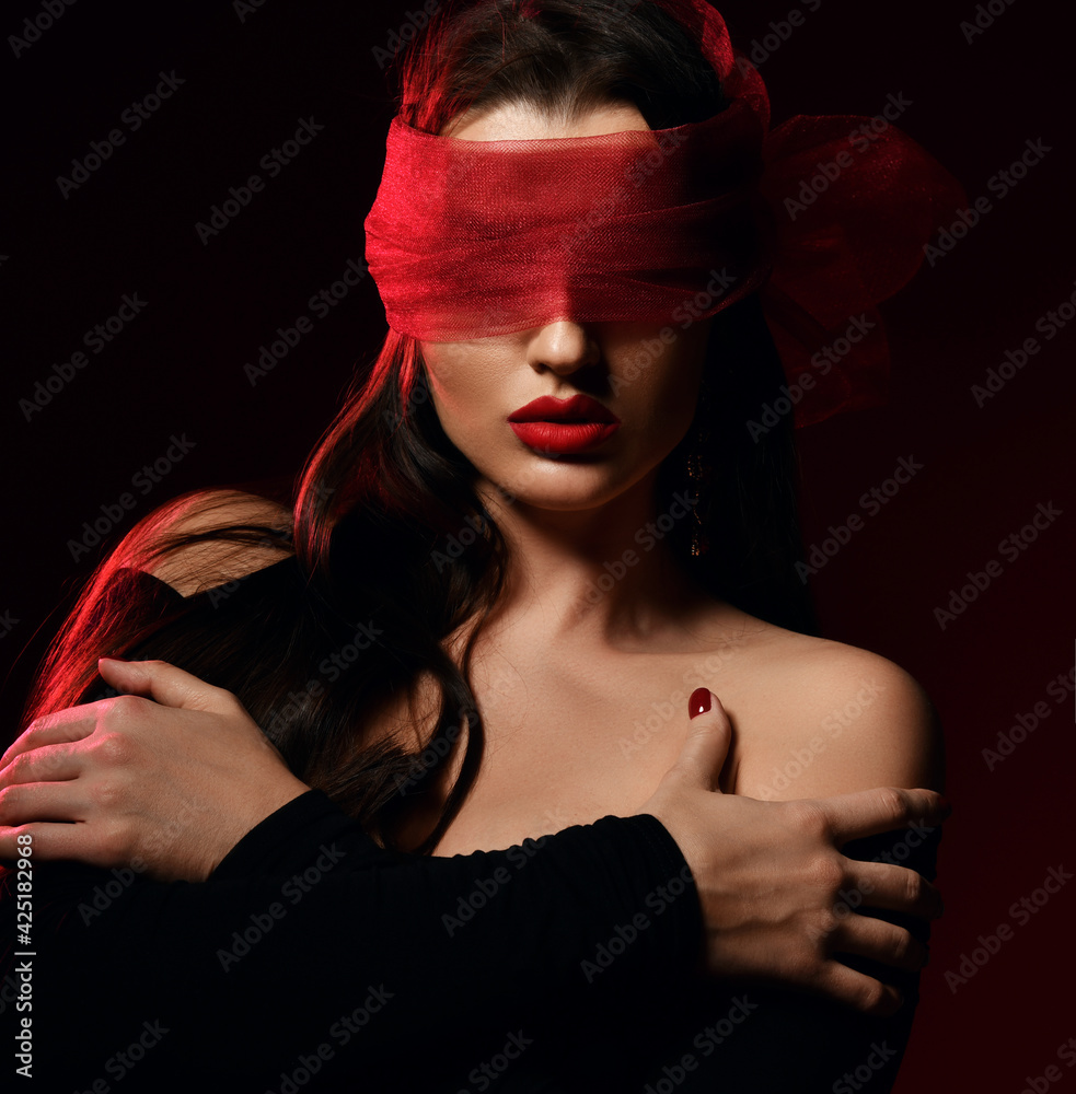 Portrait. Brunette woman vamp in off-shoulder dress and with her eyes covered with scarf, blindfold. Sex role play, games. Black background. Fashion, vogue, sexy stylish look for woman concept - obrazy, fototapety, plakaty 