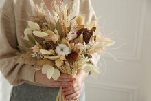 Woman Holding Beautiful Dried Flower Bouquet At Home, Closeup