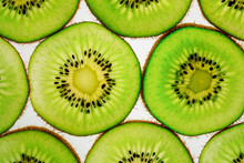 Sliced Pieces Of Kiwi Fruit Laid Out On A White Background