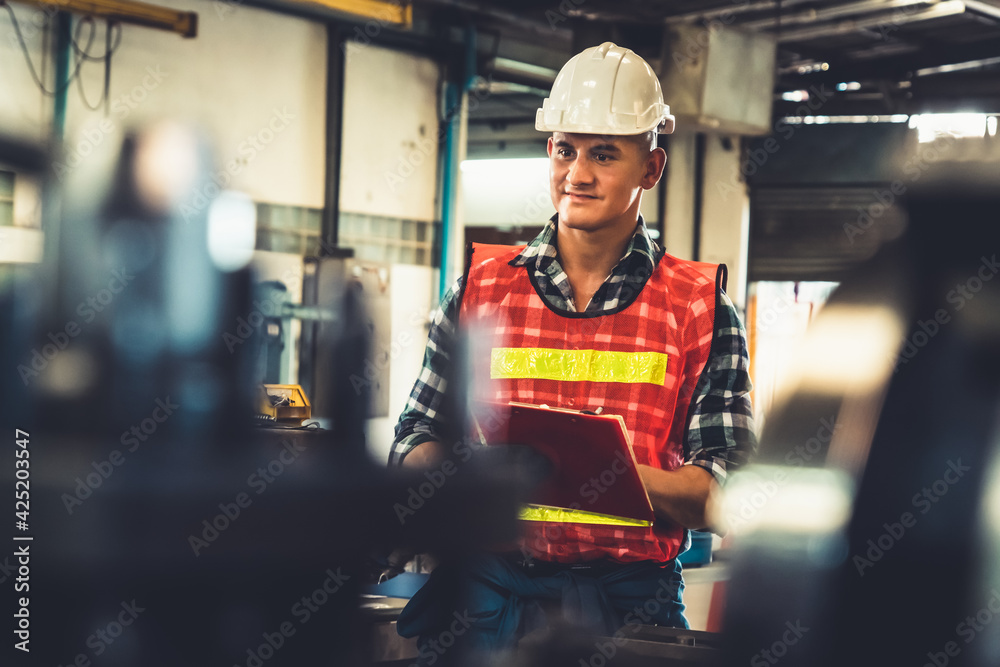 Manufacturing worker working with clipboard to do job procedure checklist . Factory production line occupation quality control concept . - obrazy, fototapety, plakaty 
