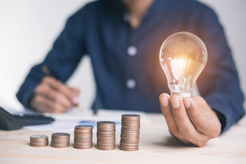 businessman holding coins putting in glass. concept saving money for finance accounting to arrange coins into growing graphs concept.