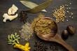 Assorted whole Indian spices spread over rustic wooden background. Aromatic and very flavorful Asian spice ingredients.