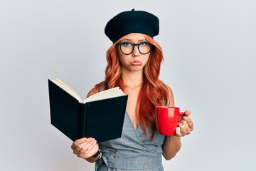 Sticker - Young redhead woman wearing french beret reading a book and drinking a coffee depressed and worry for distress, crying angry and afraid. sad expression.