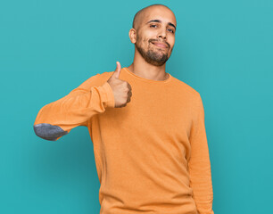 Poster - Hispanic adult man wearing casual winter sweater doing happy thumbs up gesture with hand. approving expression looking at the camera showing success.