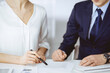 © rogerphoto - Unknown businessman and woman discussing contract in office. closeup.Business people or lawyers working together at meeting. Teamwork and partnership