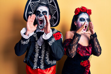 Canvas Print - Young couple wearing mexican day of the dead costume over yellow shouting angry out loud with hands over mouth