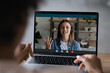 © fizkes - Close up rear view of female employee have webcam digital virtual call on laptop with coworker colleague. Biracial woman speak talk on video conference with business partner. Zoom concept.
