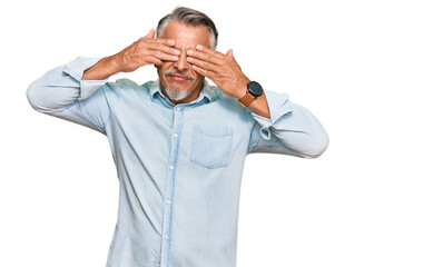 Canvas Print - Middle age grey-haired man wearing casual clothes covering eyes with hands smiling cheerful and funny. blind concept.