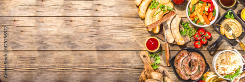 Obraz Dibond Assortment of different fried sausages. Set with various meat Bavarian, Frankfurt, German grilled sausages, Oktoberfest or summer BBQ party concept, old wooden background copy space top view