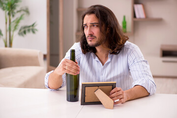 Poster - Young man drinking alcohol at home in unhappy love concept