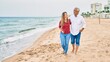 © Krakenimages.com - Middle age hispanic couple smiling happy walking at the beach.