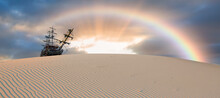 Silhouette Of Old Ship On Desert With Rainbow At Amazing Sunset 