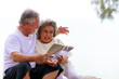 © sutthichai - Happy elderly retirement  senior  couple have fun while reading a book together.