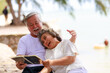 © sutthichai - Happy elderly retirement  senior  couple have fun while reading a book together.