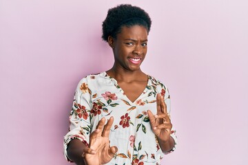 Sticker - Young african american girl wearing casual clothes disgusted expression, displeased and fearful doing disgust face because aversion reaction. with hands raised