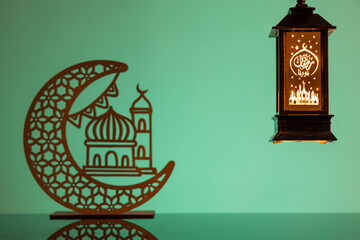 Wall Mural - Eid Mubarak concepts with lamp inscribed with arabic text translated to english as Ramadhan is our light., with crescent moon in silhouette