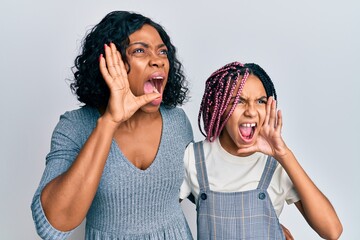 Canvas Print - Beautiful african american mother and daughter wearing casual clothes and hugging shouting and screaming loud to side with hand on mouth. communication concept.