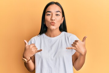 Sticker - Young asian woman doing shaka sign with hands looking at the camera blowing a kiss being lovely and sexy. love expression.