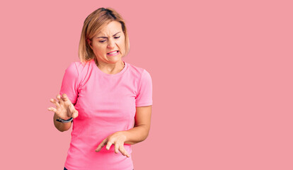 Sticker - Young blonde woman wearing sportswear disgusted expression, displeased and fearful doing disgust face because aversion reaction.