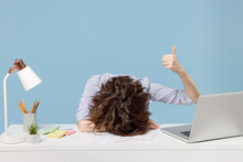Young Tired Exhausted Secretary Employee Business Woman In Shirt Sit Work Sleep Laid Her Head Down On White Office Desk With Pc Laptop Show Thumb Up Gesture Isolated On Pastel Blue Background Studio.