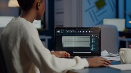Poster - Black freelancer architect working in 3D software to elaborate container design sitting at desk in business office at midnight. Focused engineer creating and studying prototype, analysing scale model